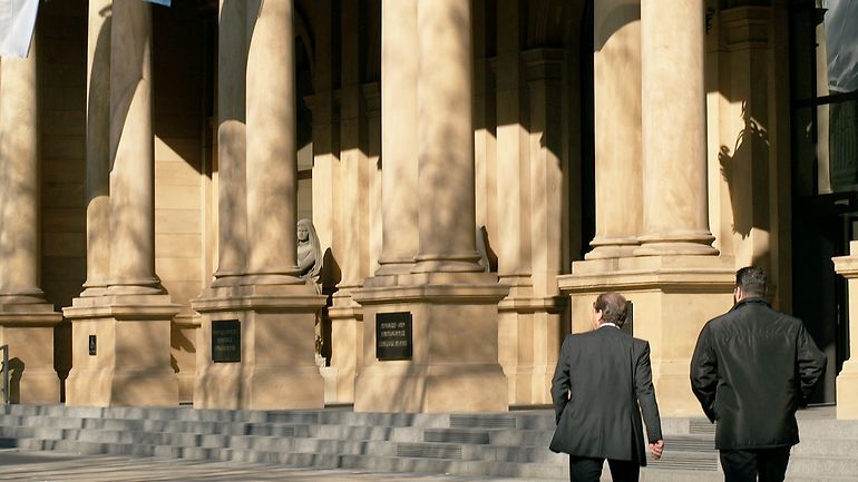 Stock Exchange building with flags and passersby